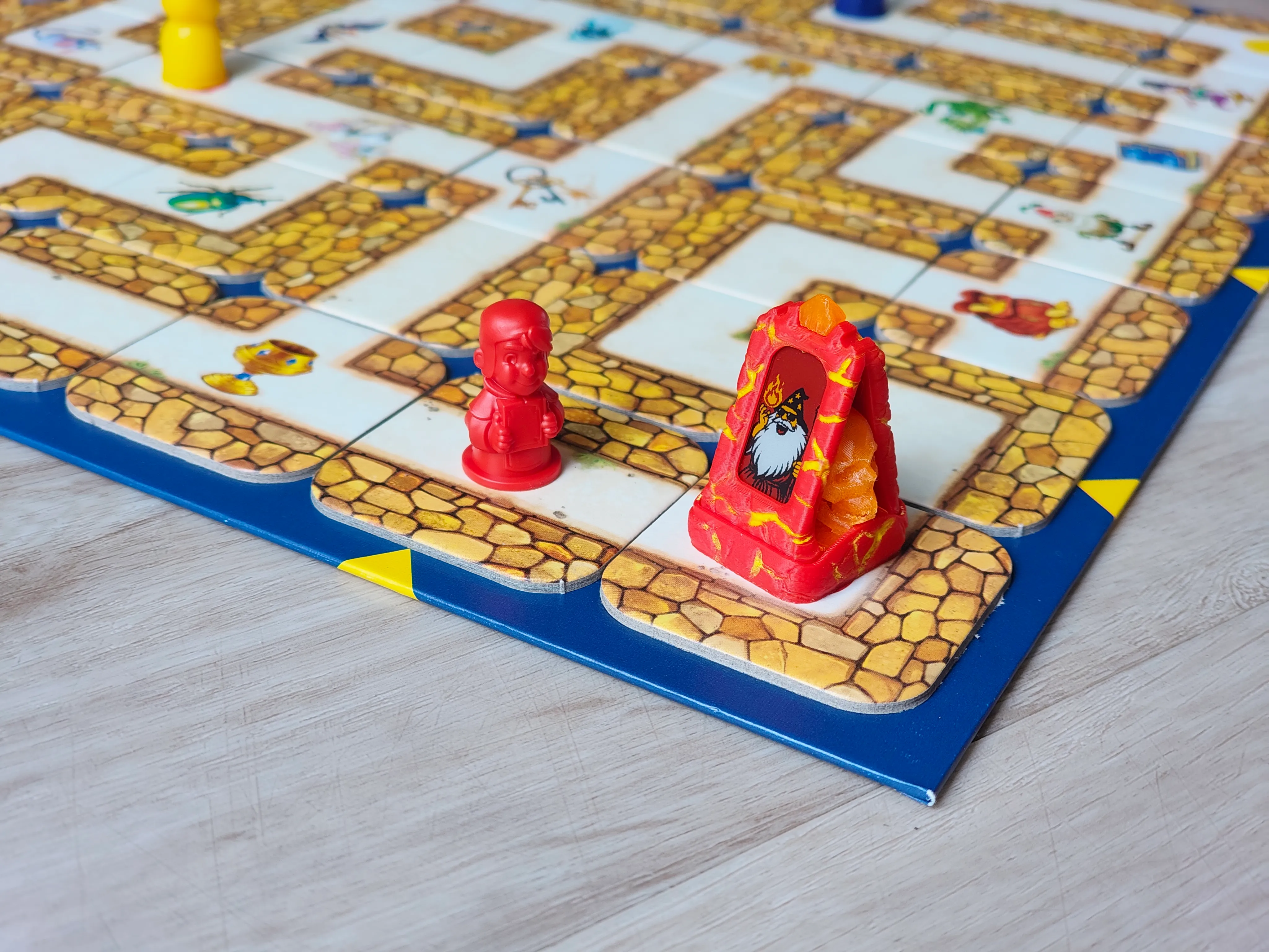 A Totem Forge mini standing on a colorful children's maze board game